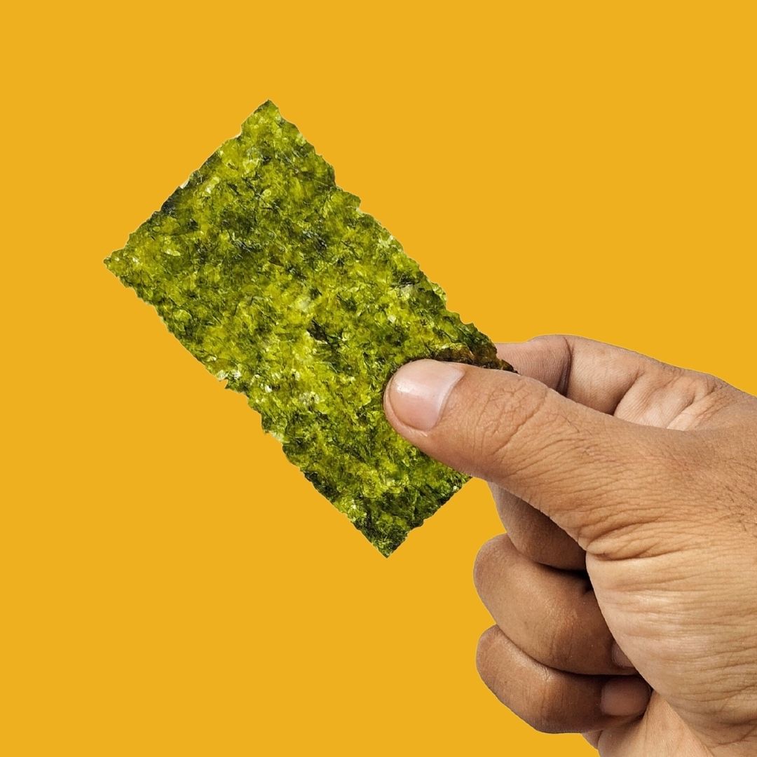 Hand holding crispy sesame oil seaweed
